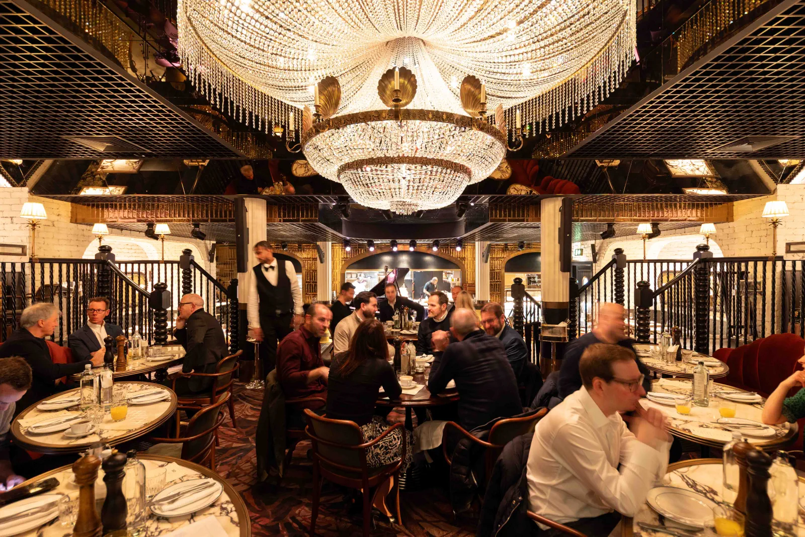 Guests dining beneath a grand chandelier at a London corporate event
